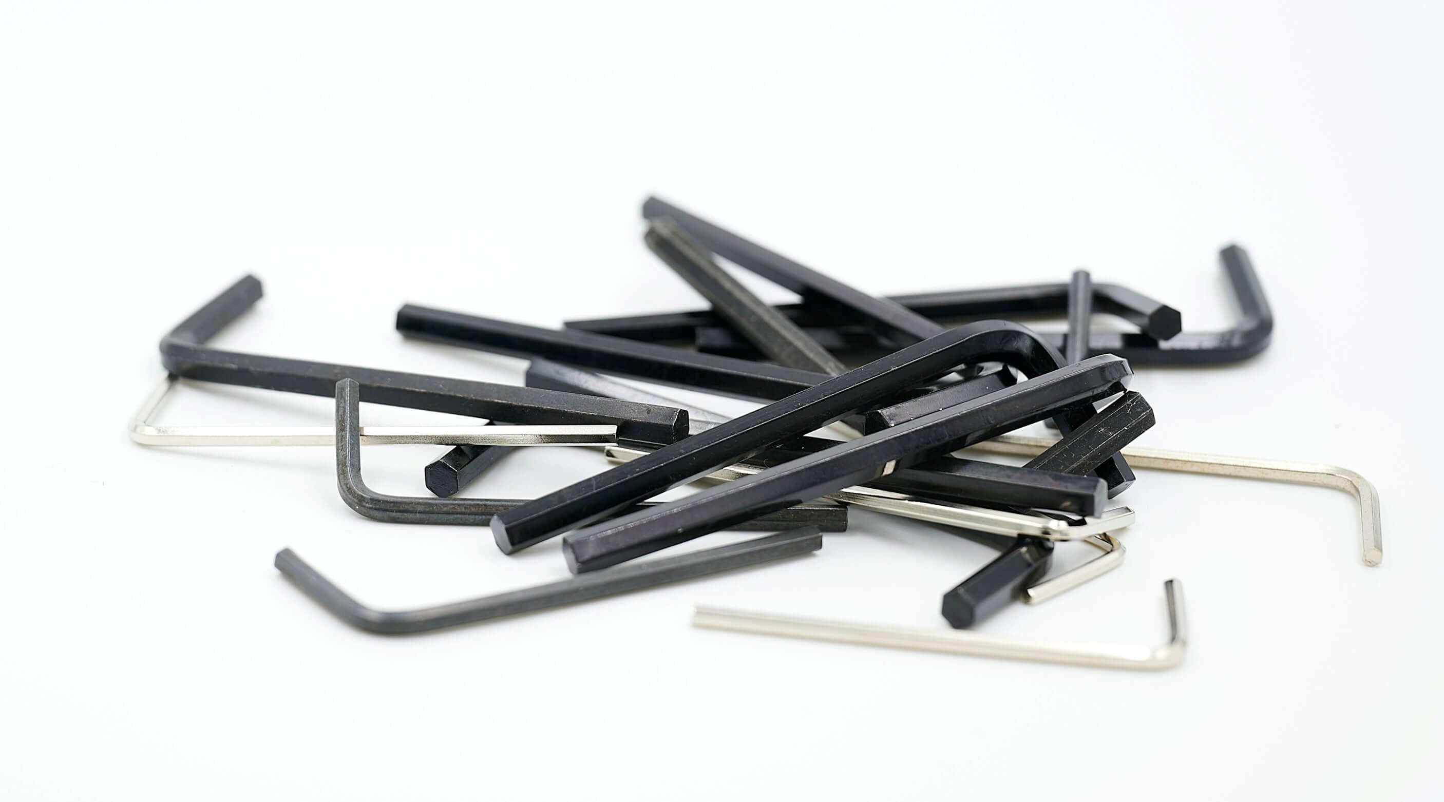 A collection of various sizes of Allen keys scattered on a white surface, ideal for DIY projects.