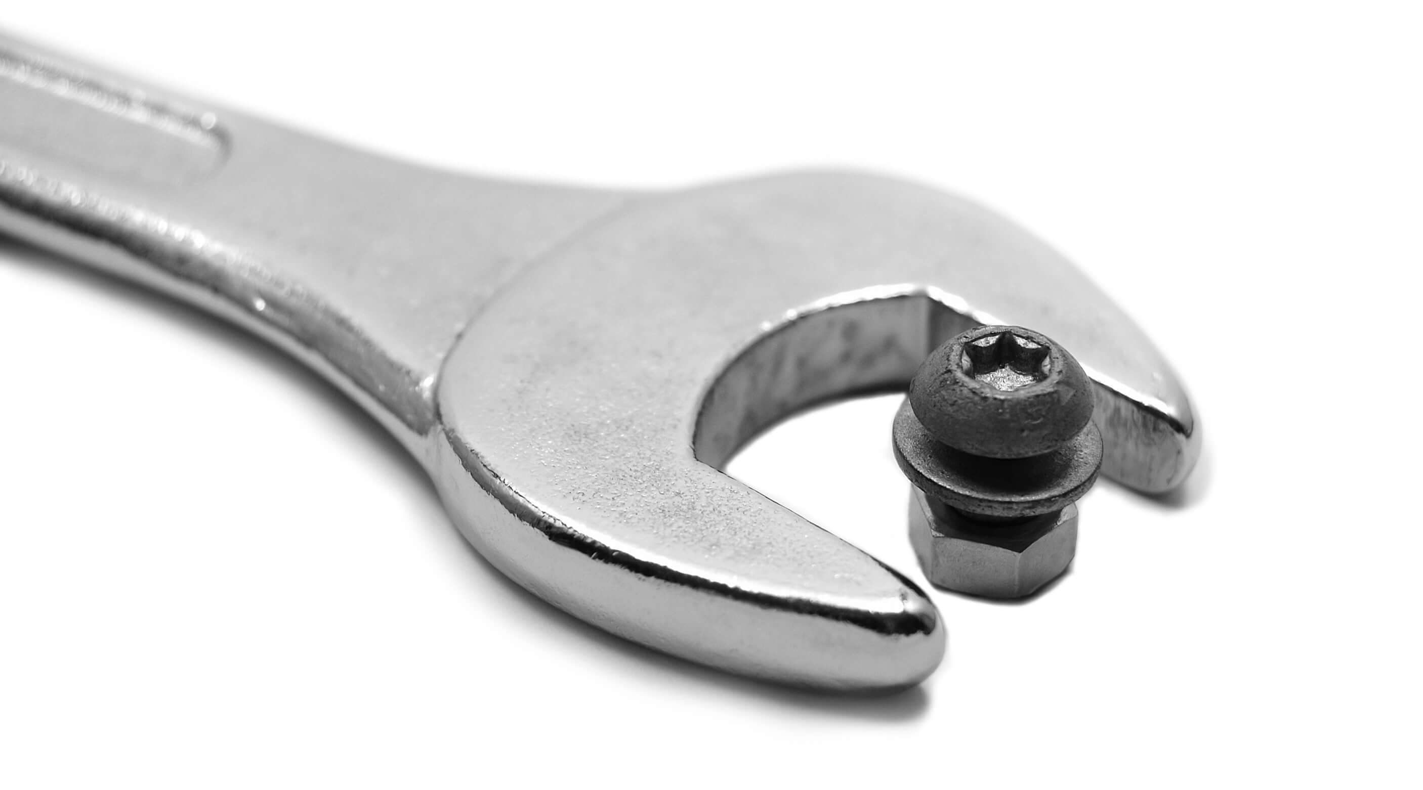 Close-up of a chrome wrench gripping an Allen bolt, illustrating a tool for removing stubborn fasteners without an Allen key.