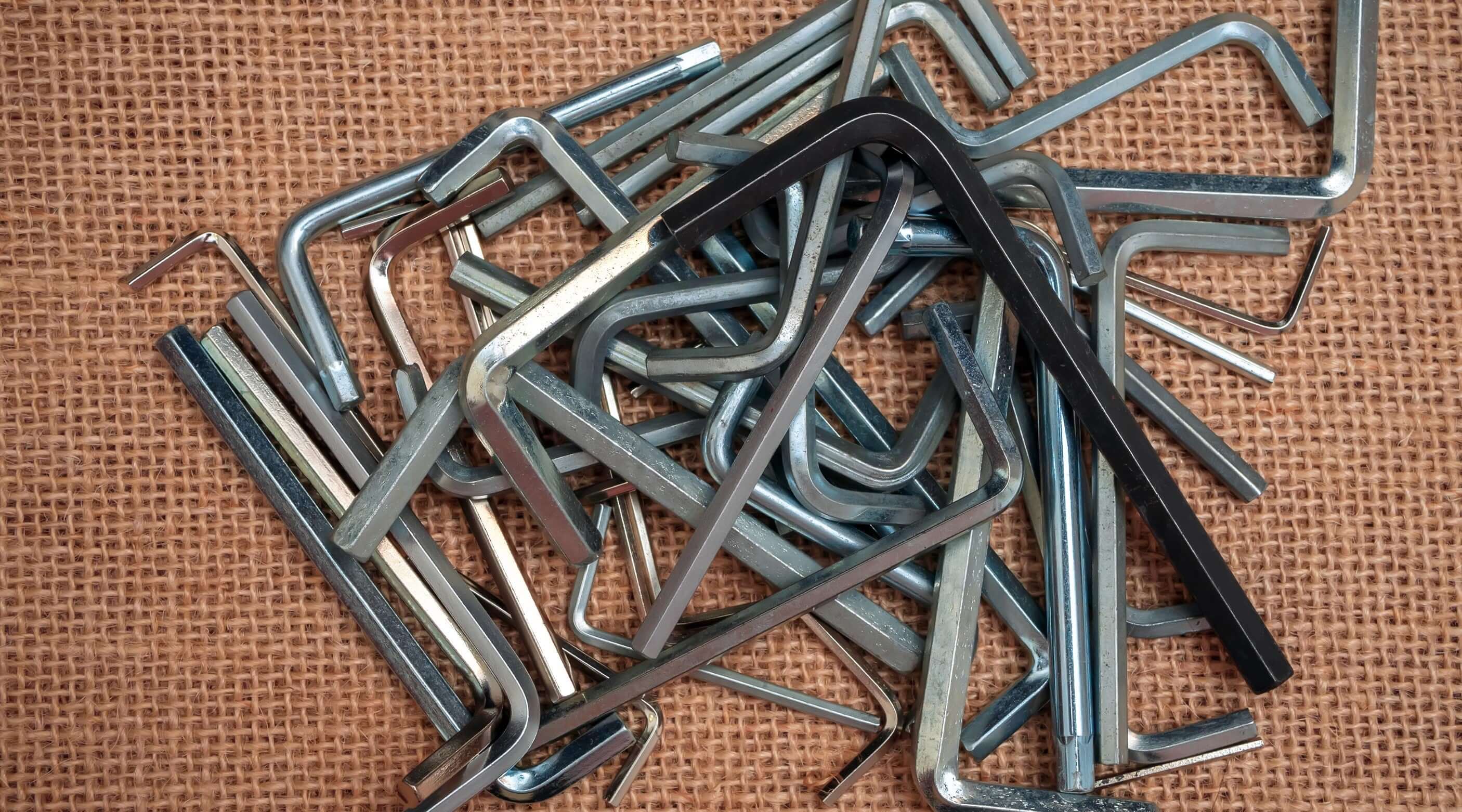 Various allen key sets including imperial and torx keys, arranged on a textured surface.