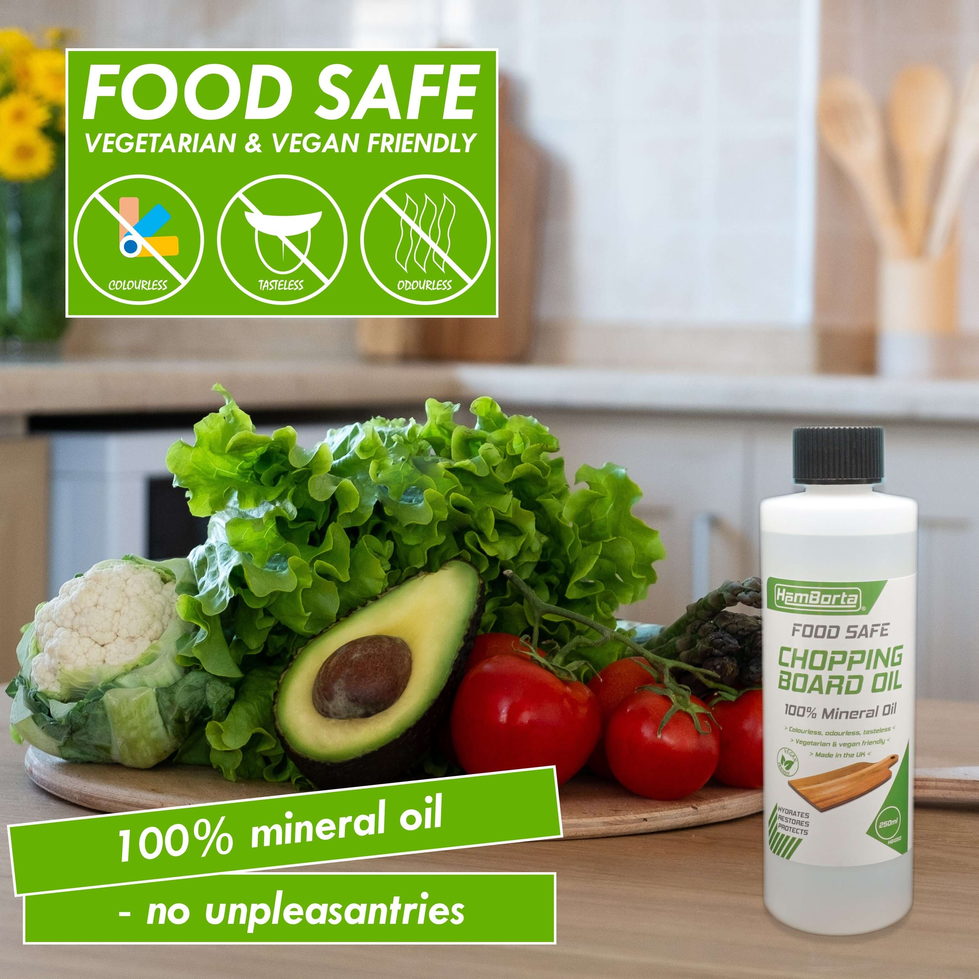 HemBorta chopping board oil bottle next to fresh vegetables, labeled food safe, 100% mineral oil for chopping surfaces.