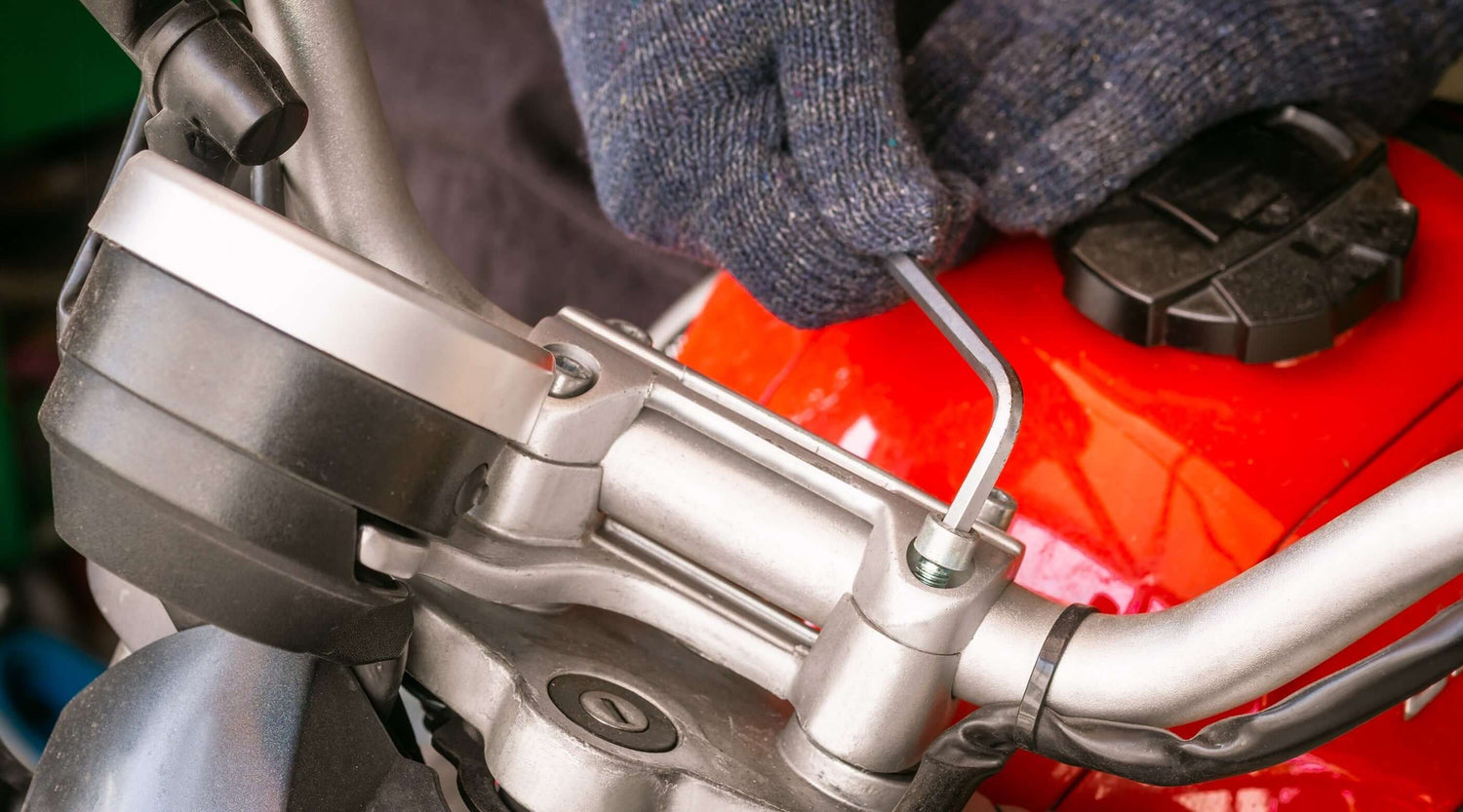 A person using an Allen key on a motorcycle handlebar, showcasing the tool in action.